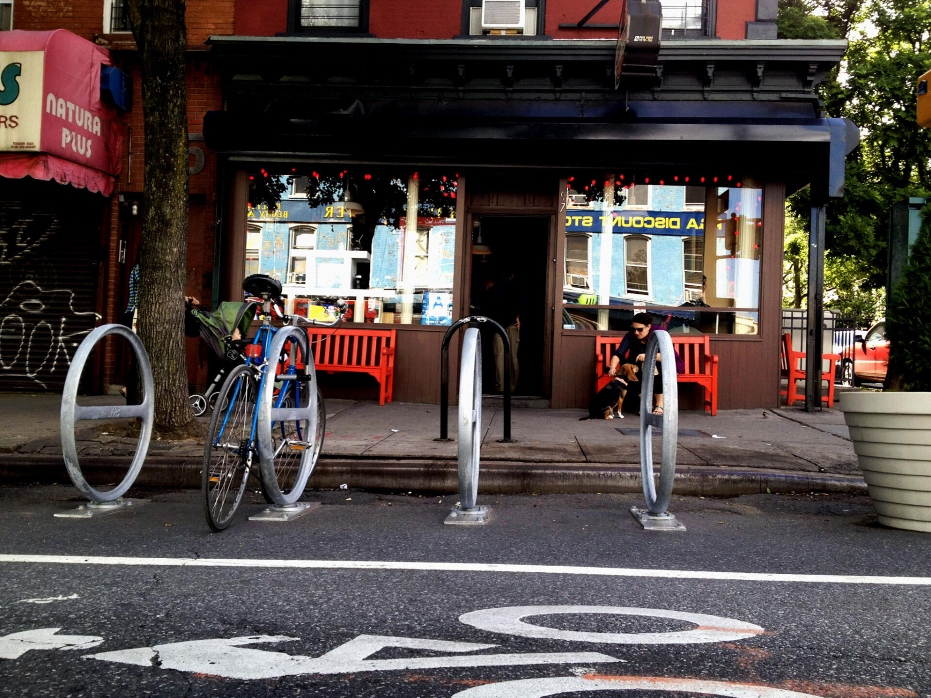 one bike parked at a bike corral that is in the street