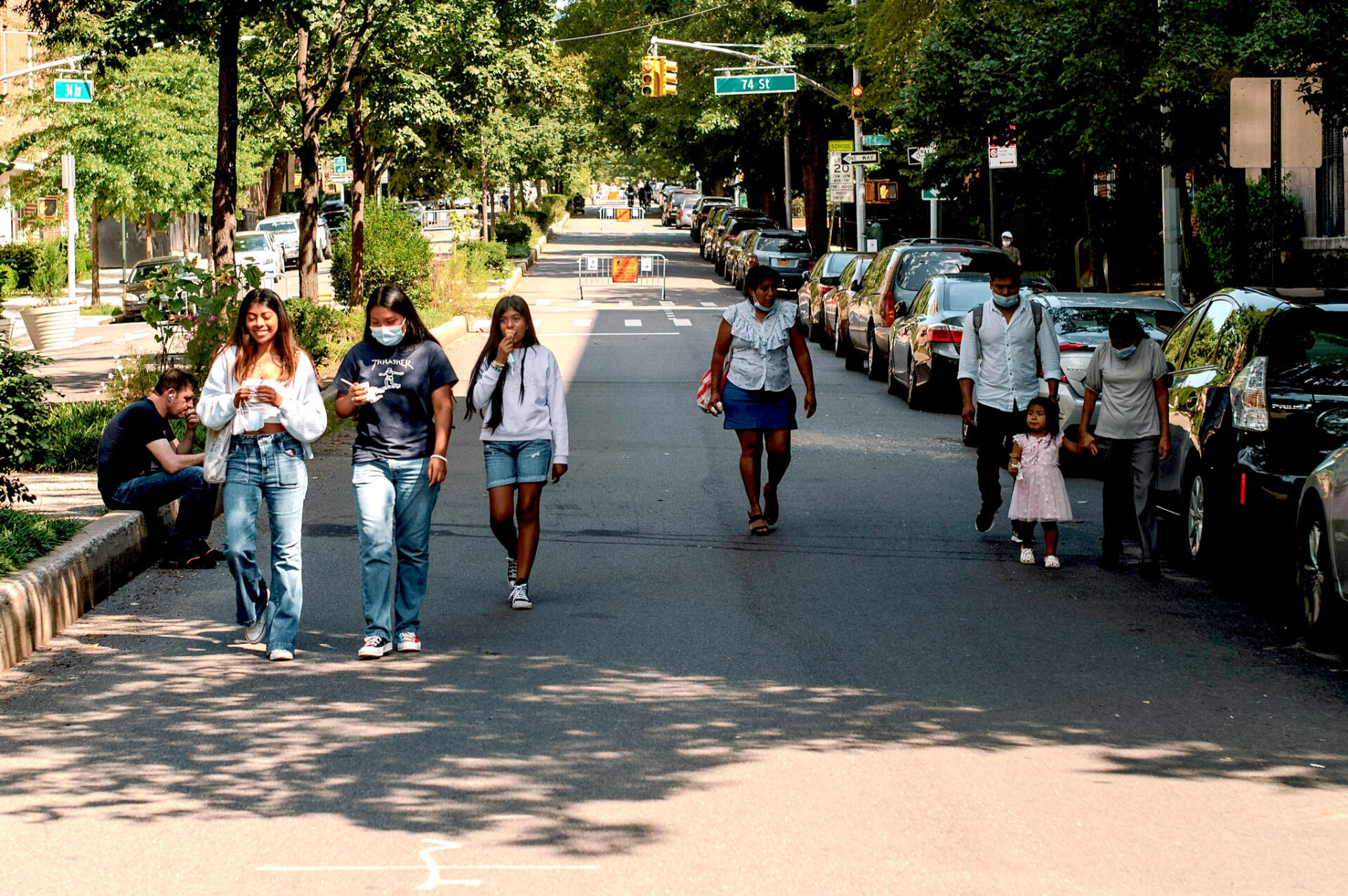 a group of people walking down a street closed to thru car traffic
